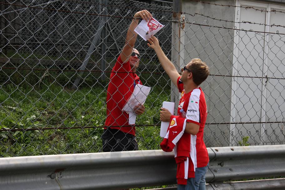 Un tifoso approfitta di Vettel per un autografo ravvicinato. Colombo